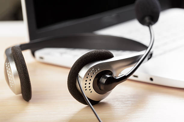 istock Headset resting on a desk next to a laptop during a work session 2246139663