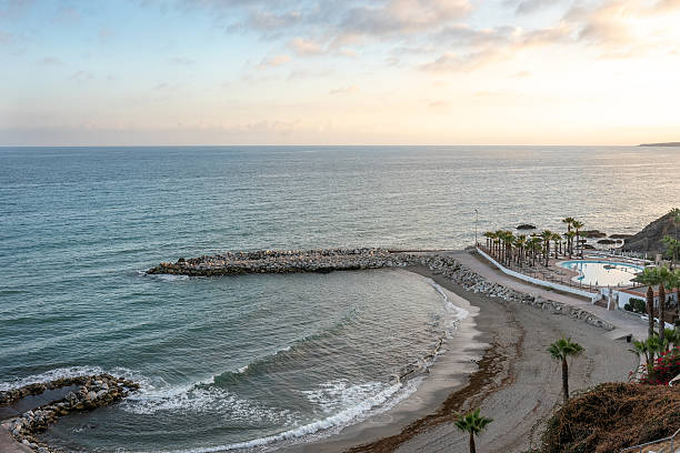 istock Serene coastal landscape with gentle waves and palm trees at sunset 2246144638