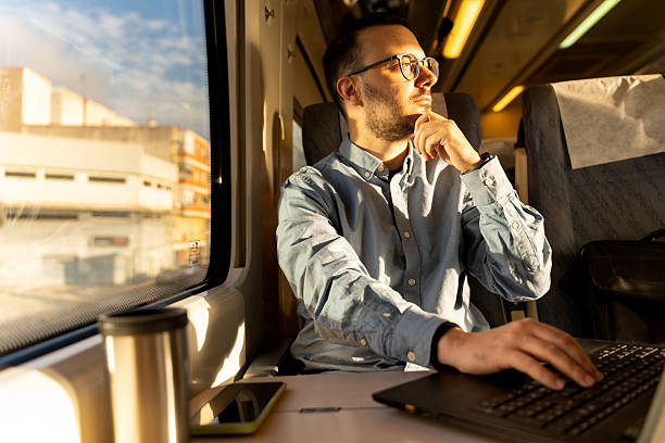 istock Man traveling by train working on laptop 2246144662