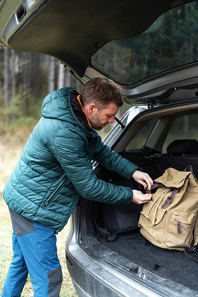 istock Man preparing backpack for road trip in car trunk 2246148279