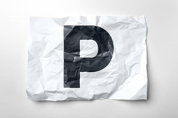 Crumpled white paper displays a bold black letter P in a simple indoor environment.