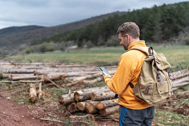 istock Man hiking and navigating with smartphone in nature 2246149538