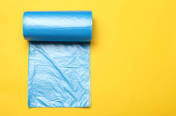 istock Roll of blue garbage bags on yellow background 2246153790