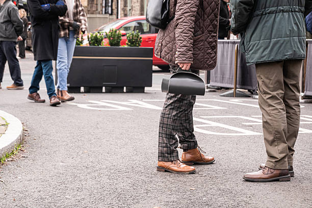 Two people in briwn tweed holding takeaway box - autumn street scene