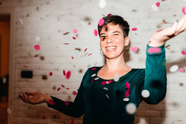 istock Woman Tossing Confetti at Festive Home Celebration 2246155865
