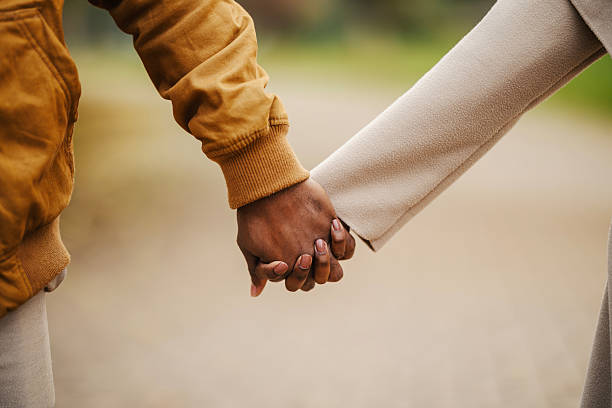 istock Diverse couple holding hands, walking outdoors together 2246156226
