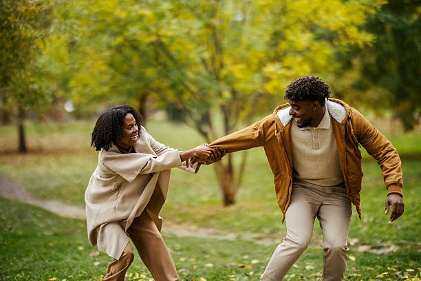 istock Happy black couple enjoying playful autumn park outing 2246156379