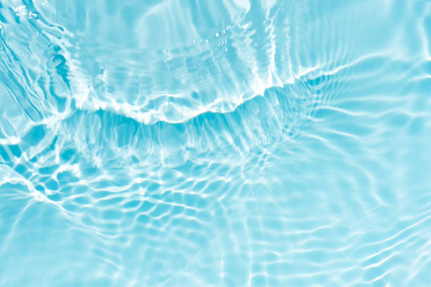 istock Blue water with ripples on the surface. Defocus blurred transparent blue colored clear calm water surface texture with splashes and bubbles. Water waves with shining pattern texture background. 2246156430