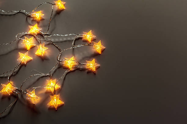 istock Star shaped fairy lights glow on a dark surface during the evening 2246156632