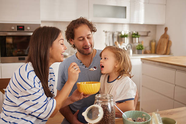 istock Parents feeding child breakfast in modern kitchen 2246157592