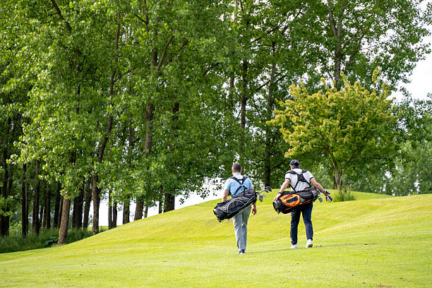 istock Two Golfers Walking with Clubs on Lush Fairway 2246157642