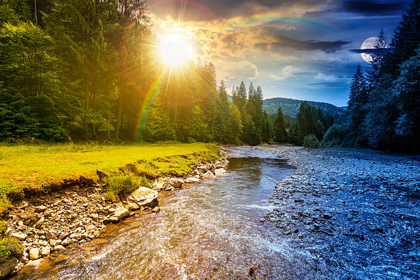 istock landscape with mountains, forest and a river in front. day and night time change concept 2246158972