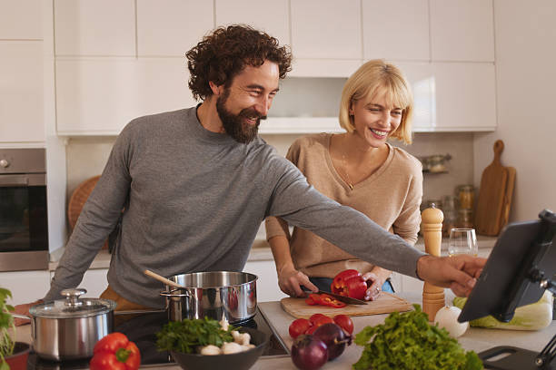 istock Happy couple cooking healthy meal using digital tablet in kitchen 2246160099