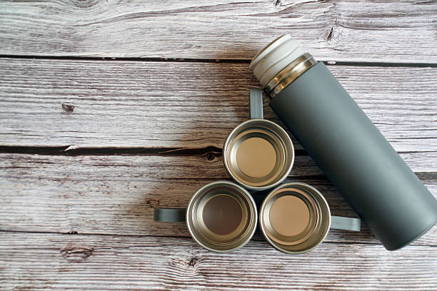 istock A thermos with mugs on a table. A thermos with cups on a wooden background. 2246160195