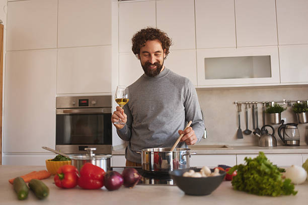 istock Happy man cooking healthy dinner in modern kitchen 2246160345