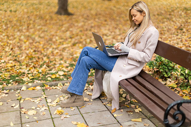 istock Woman in park working on her her laptop 2246160527