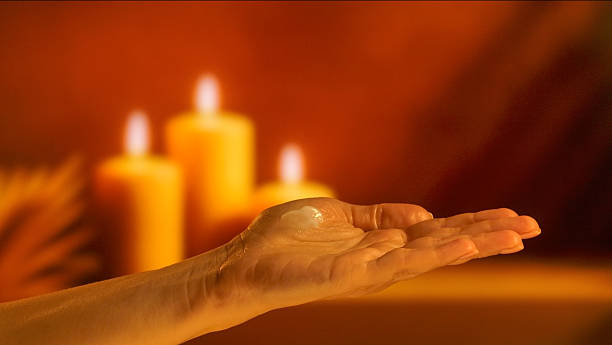 istock Hand Holding Cream with Candlelight Background 2246161360