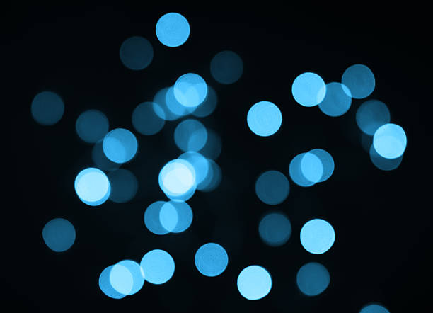 istock Blue bokeh lights in blur on black background. Selective focus. 2246161491
