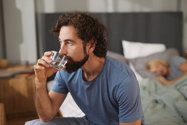 istock Thoughtful man drinking water in bedroom morning routine 2246162250