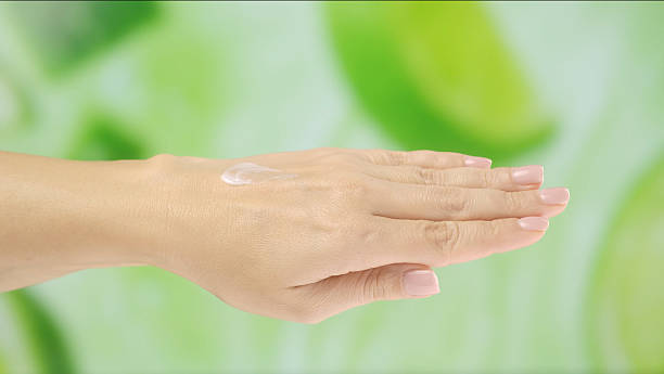 istock Hand with Cream Against Green Nature Background 2246163236