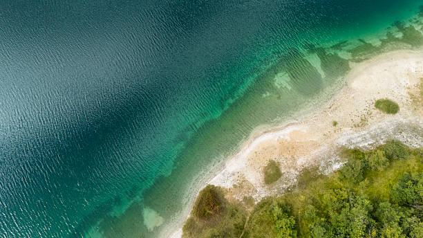 istock Beautiful Forest Edge and Clear Mountain Lake Shoreline with Vibrant Greenery 2246164402