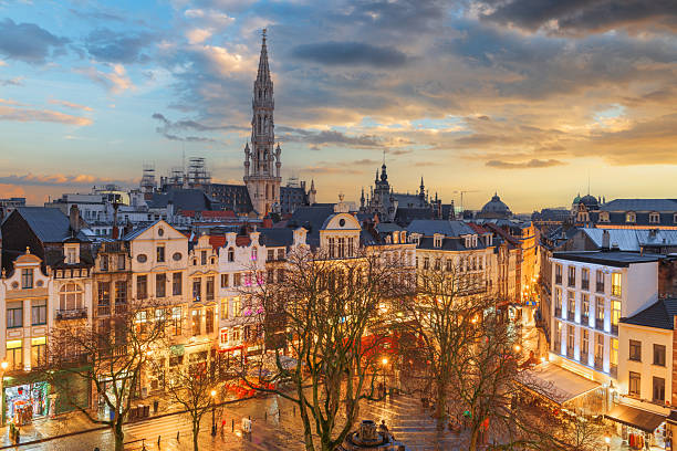 Brussels, Belgium plaza and skyline with the Town Hall tower at dusk.