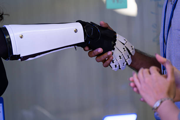 istock Human hand shaking with a robotic arm symbolizes partnership between humans and artificial intelligence. Concept of technology collaboration, future innovation, robotics, automation, and teamwork. 2246166562