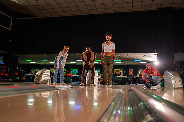 istock Group of young friends enjoying a lively bowling night, laughing and competing while playing together in a vibrant alley atmosphere 2246166571