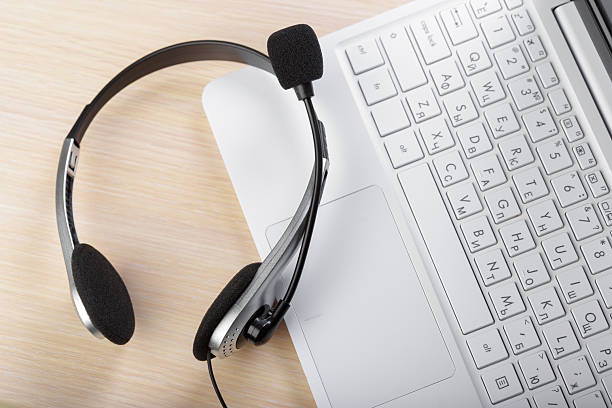 istock Headset placed on laptop keyboard for online communication setup in home office 2246167286