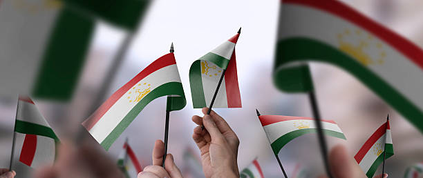 istock Tajikistan flags in their hands on a blurred urban background 2246168622