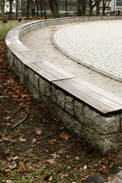 istock Public Park Seating Curve – Stone Wall with Wooden Bench Surface 2246169069