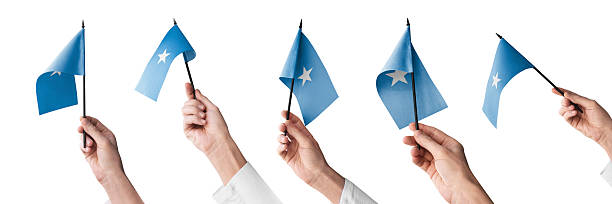 The Somalia flag in hand in different angles on a white background.
