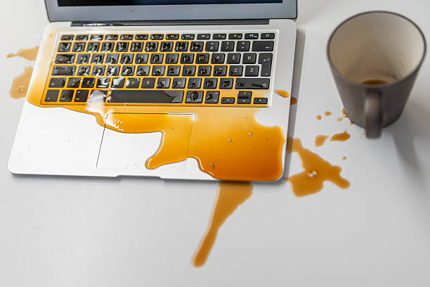 istock Unfortunate Liquid Mess Spreading Across Laptop Keyboard with Empty Mug Nearby 2246171991