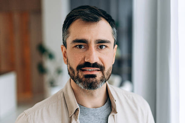 Mid adult man with beard smiling, looking directly at camera