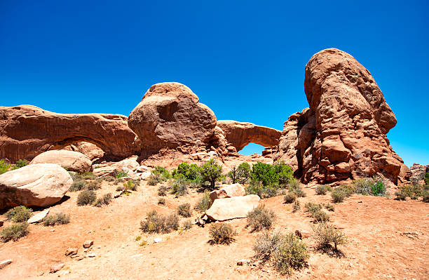 Elephant Arch, unique sandstone formation in Arches National Park Utah under bright sky.