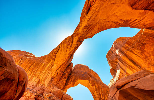 Massive Double Arch formation in Arches National Park Utah with dramatic desert landscape.