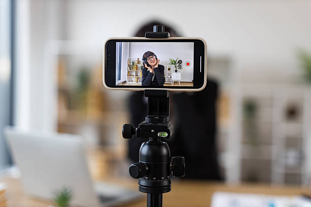istock Woman Recording Video with Smartphone in a Modern Office Setting 2246178476