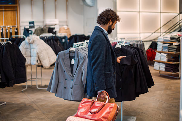 istock Man browsing clothes and shopping in a clothing store 2246179568