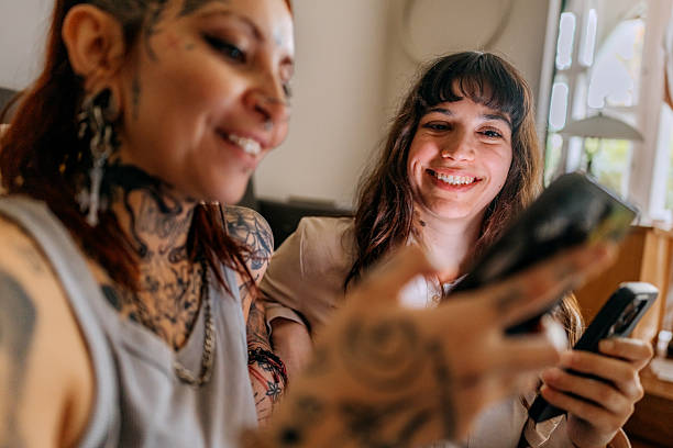 istock Two female friends using mobile phones at home 2246181583