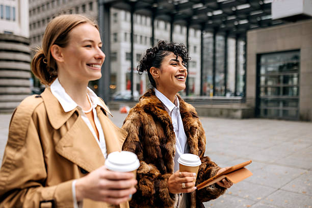 istock Two female coworkers using digital tablet and having coffee break in city 2246181817