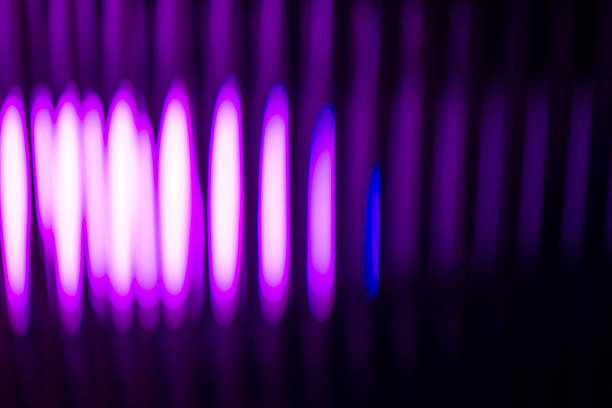 An abstract, vibrant purple light source creating vertical, rhythmic streaks on a dark, mysterious background.