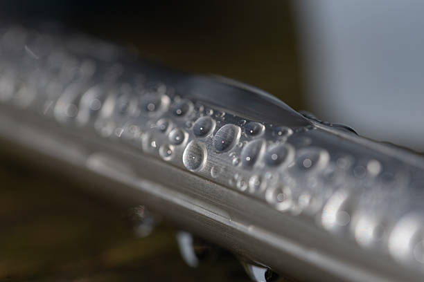 Abstract macro close-up of water droplets on a smooth surface, creating a minimal and calming background with soft light and shallow depth of field.