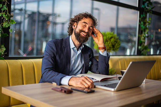 istock Businessman enjoying music while working remotely in cafe 2246185934