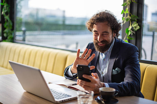 istock Businessman making video call on smartphone in cafe 2246186108