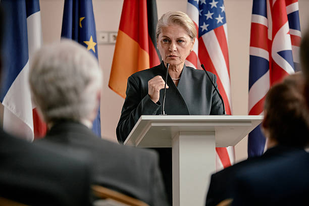 istock Senior Caucasian Woman Gesturing While Leading Discussion at Global Forum 2246186949