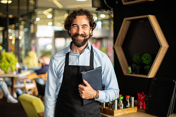 istock Smiling waiter holding menu offering restaurant service 2246186995