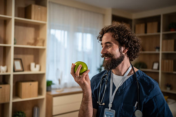 istock Doctor holding green apple explaining healthy eating 2246191359