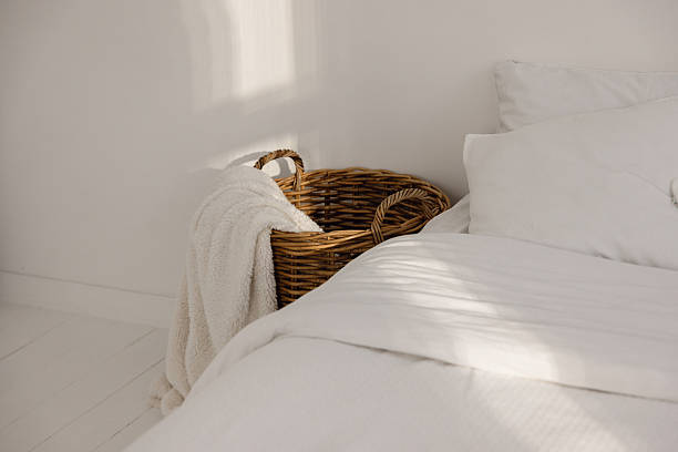 istock Minimalist Bedroom with White Bedding and Wicker Basket Headboard 2246192240