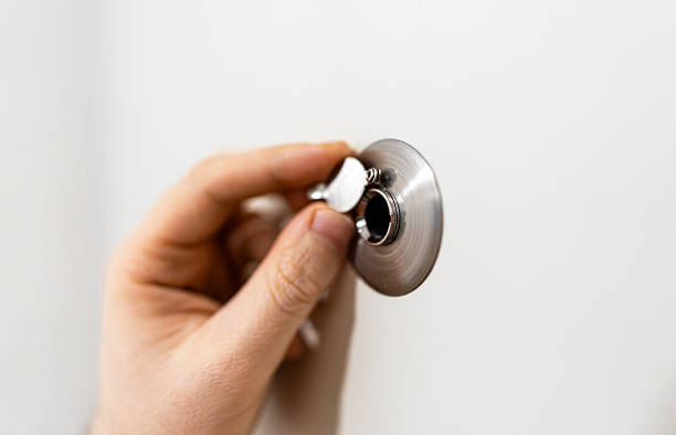 istock Man opens the door peephole cover. 2246194611