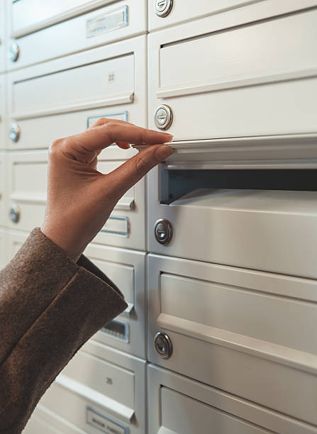 istock Woman checking mailbox in apartment building. 2246195203